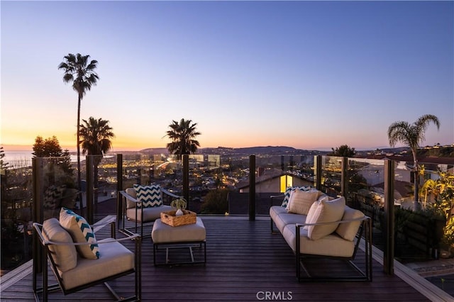 deck at dusk featuring an outdoor hangout area