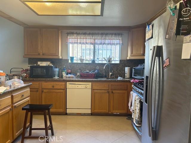 kitchen featuring stainless steel appliances, sink, and decorative backsplash