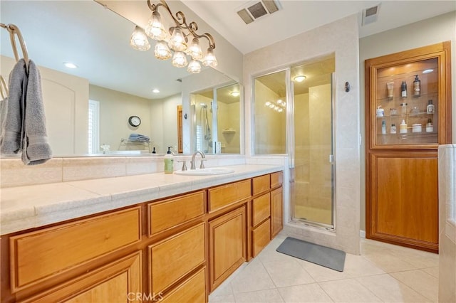 bathroom featuring vanity, a shower with shower door, and tile patterned floors