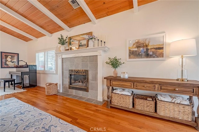 interior space with hardwood / wood-style flooring, vaulted ceiling with beams, wooden ceiling, and a fireplace