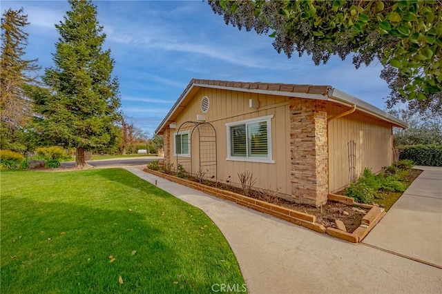 view of side of home with a yard