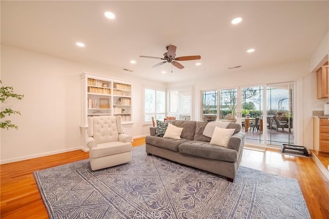 living room featuring ceiling fan and light hardwood / wood-style floors