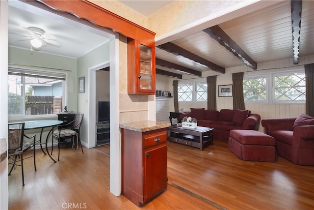 living room with light wood-type flooring, track lighting, ceiling fan, and beam ceiling