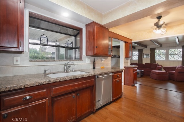 kitchen featuring sink, light hardwood / wood-style floors, stainless steel dishwasher, and a wealth of natural light