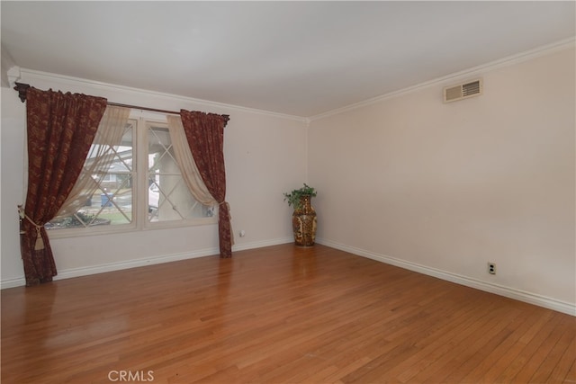 unfurnished room with hardwood / wood-style flooring and crown molding