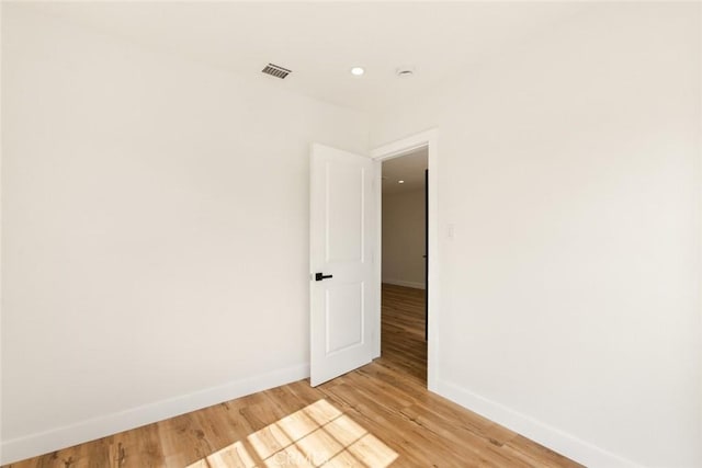 unfurnished room with recessed lighting, baseboards, visible vents, and light wood finished floors