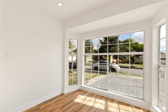 doorway to outside featuring light wood finished floors, baseboards, and recessed lighting