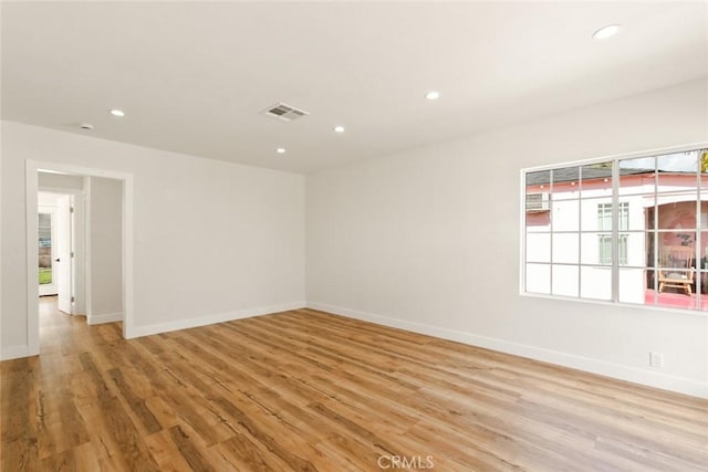 unfurnished room featuring baseboards, light wood finished floors, visible vents, and recessed lighting