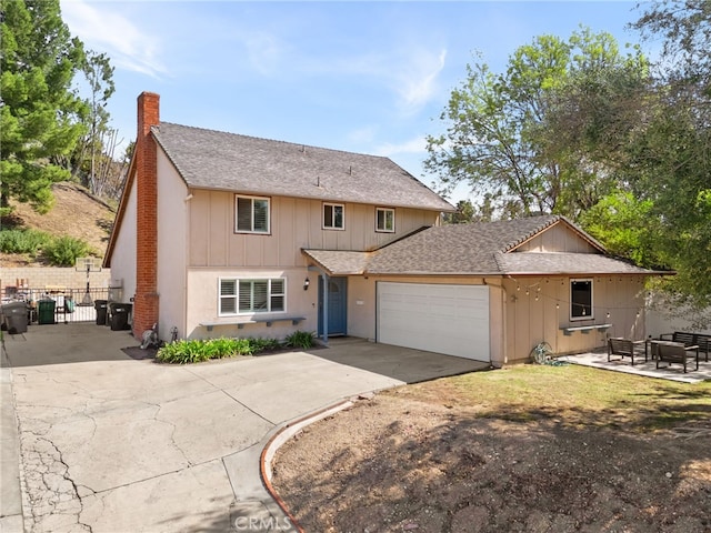 traditional-style house with a chimney, board and batten siding, fence, a garage, and driveway