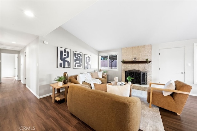 living room with vaulted ceiling, dark hardwood / wood-style floors, and a fireplace