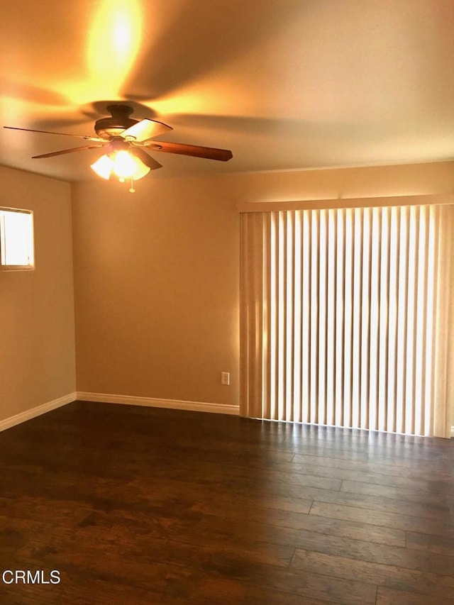 spare room with dark wood-type flooring and ceiling fan