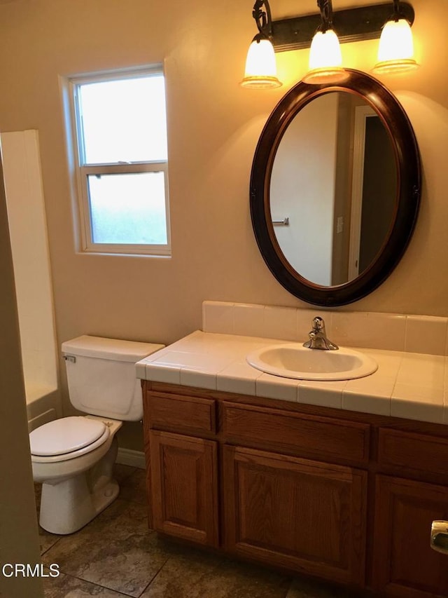 bathroom with vanity, a bathtub, and toilet