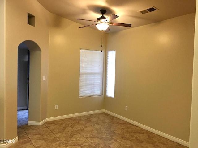 tiled spare room featuring plenty of natural light and ceiling fan