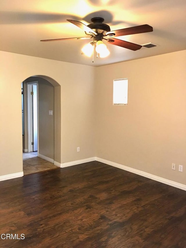 empty room with dark hardwood / wood-style floors and ceiling fan