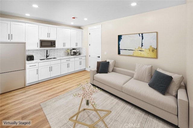 living room featuring light hardwood / wood-style floors and sink