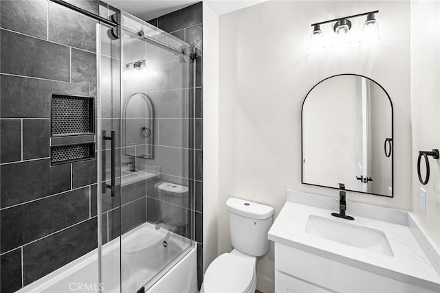 full bathroom featuring toilet, vanity, and bath / shower combo with glass door
