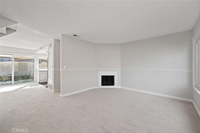 unfurnished living room with carpet floors and a textured ceiling