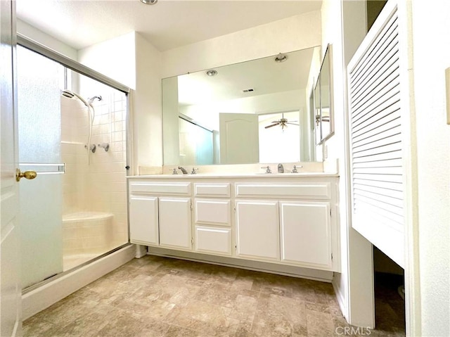 bathroom featuring ceiling fan, vanity, and a shower with door