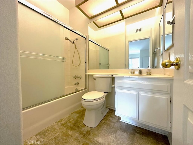 full bathroom featuring toilet, vanity, and shower / bath combination with glass door