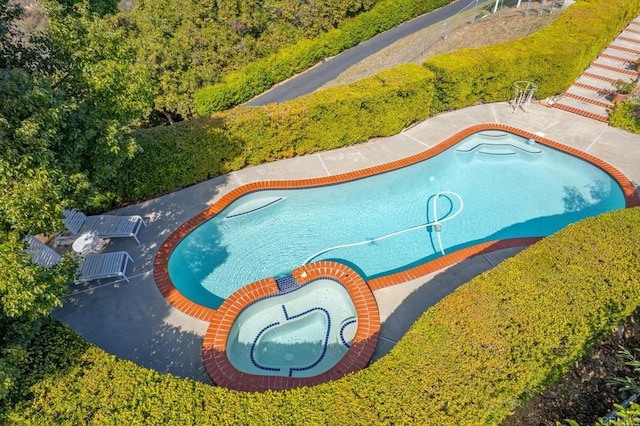 view of swimming pool featuring an in ground hot tub