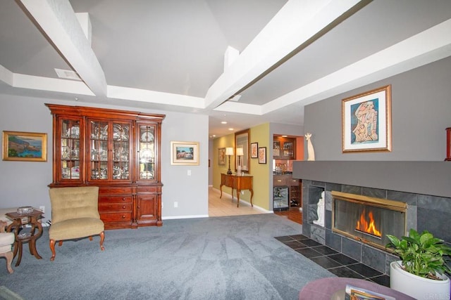 living area with dark carpet and a tile fireplace