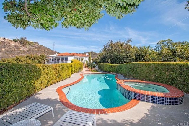 view of swimming pool featuring an in ground hot tub