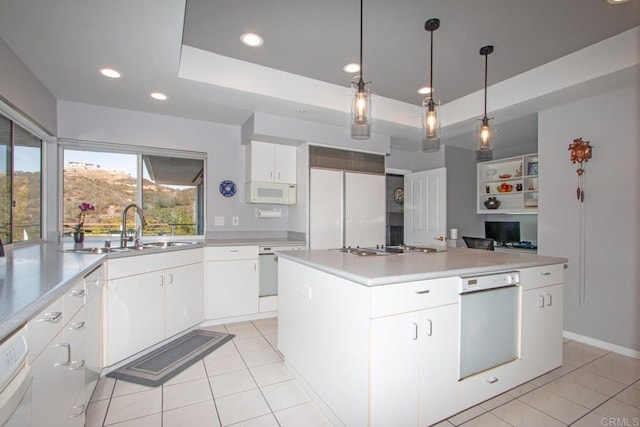 kitchen featuring sink, a center island, a raised ceiling, white appliances, and white cabinets