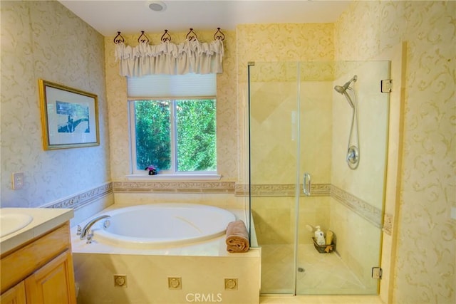 bathroom with a stall shower, a garden tub, vanity, and wallpapered walls