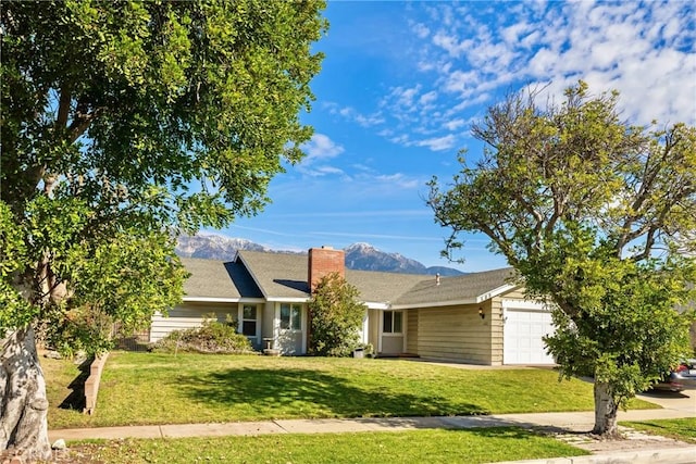 single story home with a garage, a front yard, and a mountain view