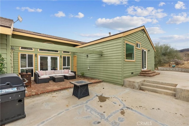 back of property featuring a patio, french doors, and an outdoor living space with a fire pit