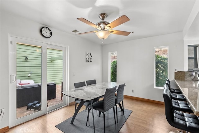 dining room with ceiling fan, a wealth of natural light, and light hardwood / wood-style flooring