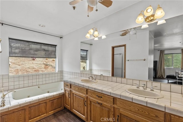 bathroom featuring vanity, hardwood / wood-style floors, a washtub, and ceiling fan