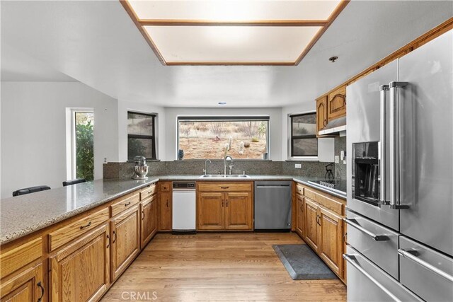 kitchen featuring appliances with stainless steel finishes, sink, kitchen peninsula, and a healthy amount of sunlight