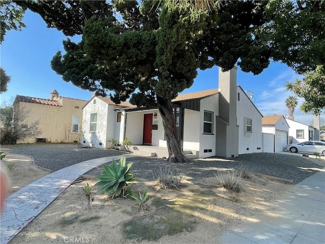 view of front of home featuring a residential view, a chimney, and stucco siding