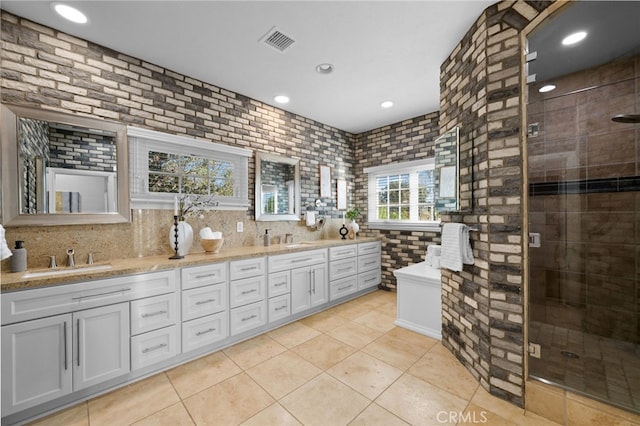 bathroom with a stall shower, visible vents, a sink, and double vanity