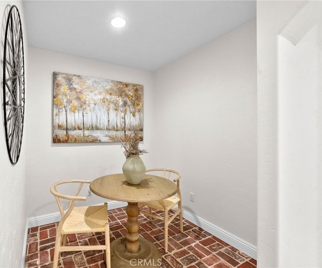 dining room featuring brick floor, baseboards, and recessed lighting