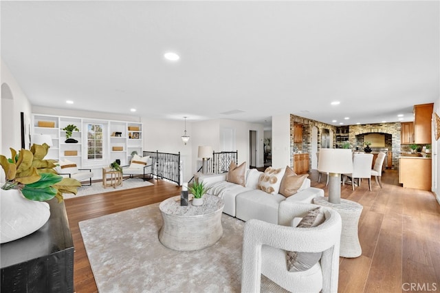 living room featuring light wood-style floors, recessed lighting, and a fireplace