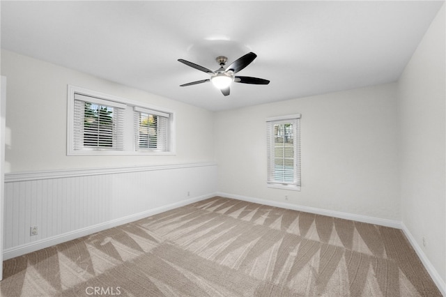 spare room featuring carpet, ceiling fan, and baseboards