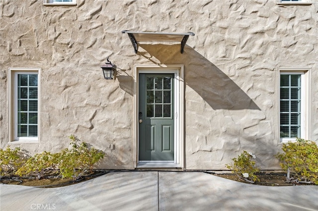 property entrance with stucco siding