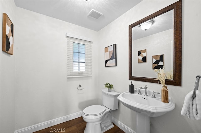 bathroom featuring visible vents, wood finished floors, toilet, and baseboards