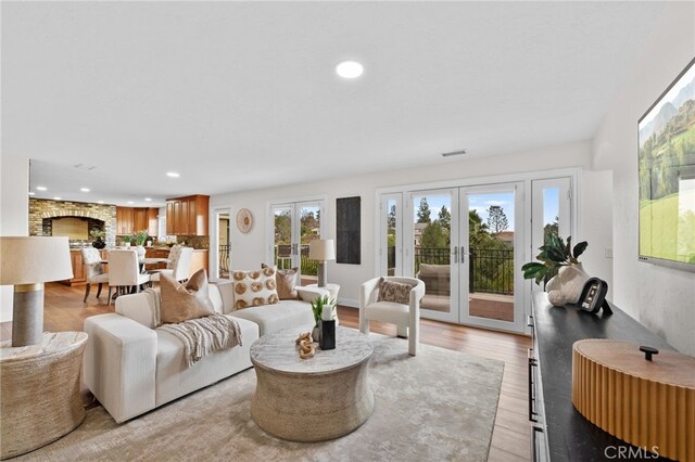 living area with french doors, recessed lighting, visible vents, and light wood-style floors