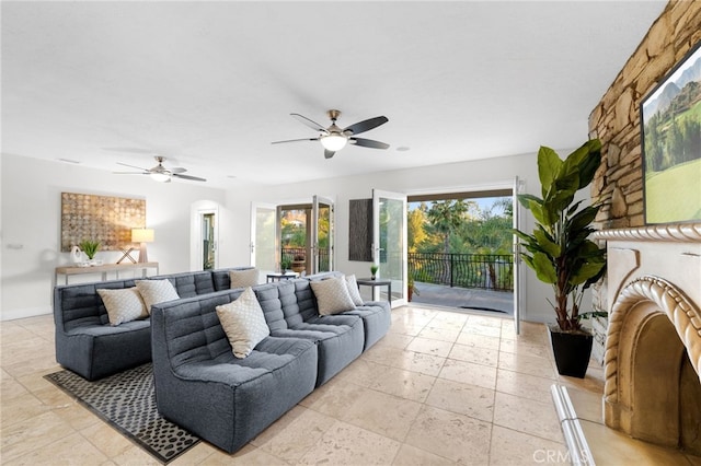 living room with a ceiling fan and baseboards