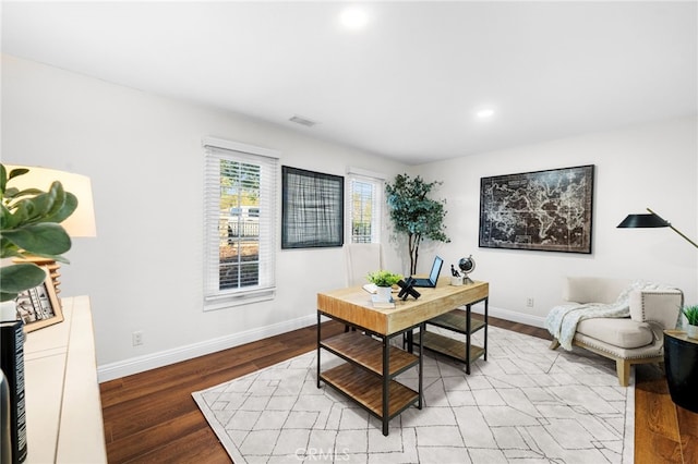 office space featuring visible vents, baseboards, and wood finished floors