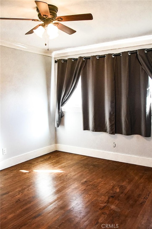 unfurnished room with ceiling fan, baseboards, wood finished floors, and ornamental molding