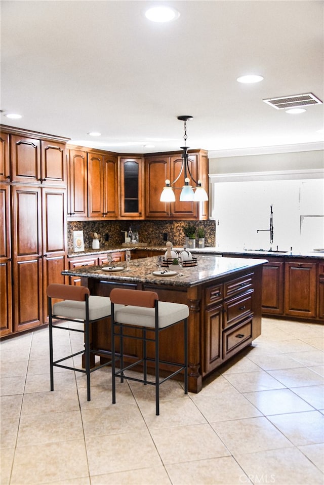 kitchen with a breakfast bar area, a kitchen island, decorative light fixtures, and decorative backsplash