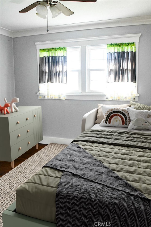 bedroom featuring crown molding, ceiling fan, and baseboards