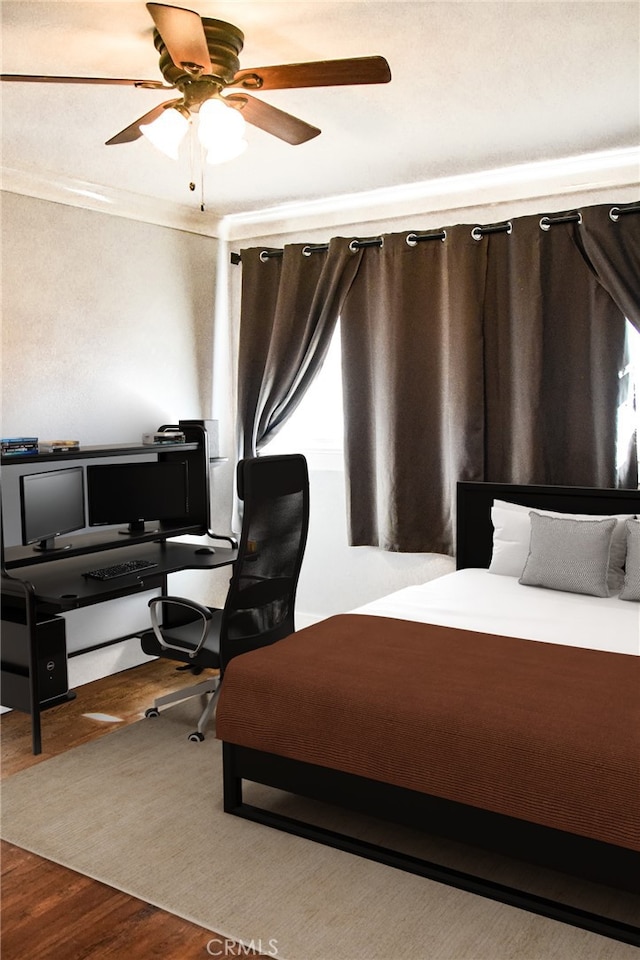 bedroom featuring ornamental molding, dark wood-type flooring, and a ceiling fan