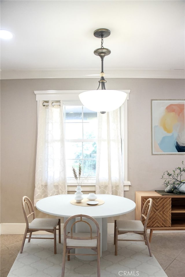 dining area featuring light tile patterned floors, baseboards, breakfast area, and crown molding