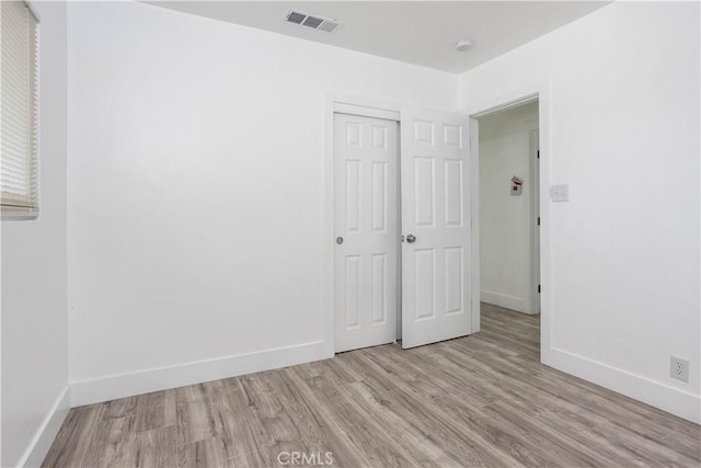 unfurnished bedroom featuring light wood-type flooring and a closet