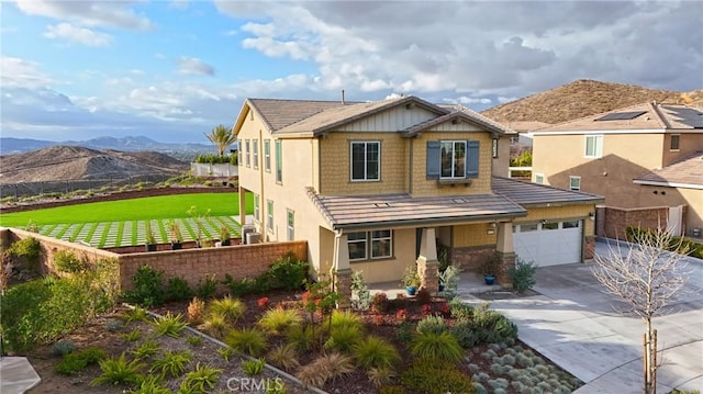 view of front of home featuring stucco siding, a porch, fence, a mountain view, and concrete driveway